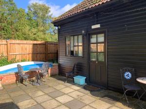 a patio with a table and chairs next to a pool at Broadwalk_2 in Coltishall