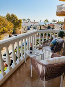 a balcony with chairs and a table with a bottle of wine at BOHO HOUSE MALAGA in Málaga