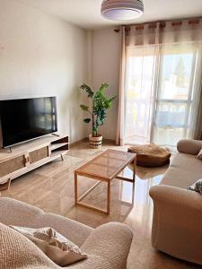 a living room with a television and a table at BOHO HOUSE MALAGA in Málaga