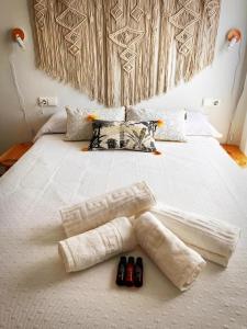 a bed with two towels and two bottles on it at BOHO HOUSE MALAGA in Málaga