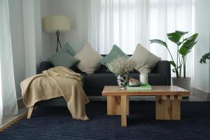Sewaro Homestay في آيزاول: غرفة معيشة مع أريكة وطاولة قهوة