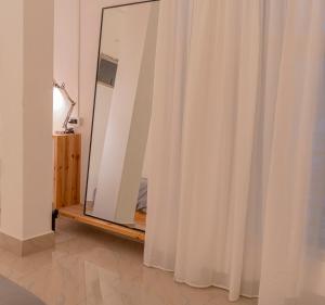 espejo en una habitación con cortinas blancas en Sewaro Homestay en Āīzawl