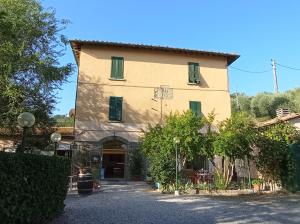 ein großes gelbes Gebäude mit grünen Rollläden in der Unterkunft Locanda Prato d'Era in Volterra