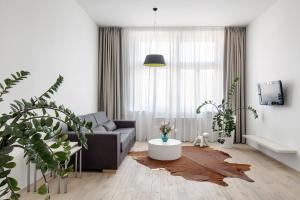 uma sala de estar com um sofá e uma mesa em Holečkova Apartments em Praga