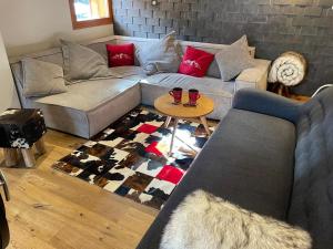 uma sala de estar com um sofá e uma mesa em MORZINE GUEST CHALET HYPERCENTER Jacuzzi et Sauna em Morzine