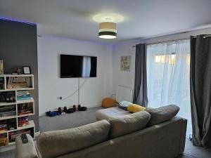 a living room with a couch and a flat screen tv at Bridgepay Double Room in Kenton