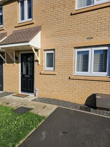 a brick house with a black door and a driveway at Bridgepay Double Room in Kenton