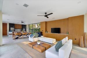 ein Wohnzimmer mit weißen Möbeln und ein Esszimmer in der Unterkunft Villa Serangan - Private Beach Access in Selong Belanak