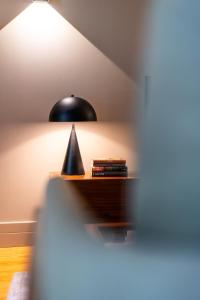 een zwarte lamp op een tafel in een kamer bij AVUS M Suites and Apartments by DA'HOME in Porto
