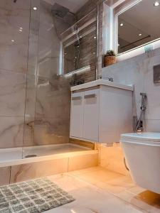 a bathroom with a shower and a toilet and a sink at Two Bedroom Apartment near Central Line in London