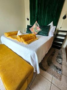 a bedroom with a large bed with yellow blankets at Adante Lodge & Conferencing in Mthatha