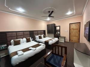 een hotelkamer met 2 bedden en een televisie bij Fair Mount in Srinagar