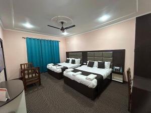um quarto com 2 camas e uma cortina azul em Fair Mount em Srinagar