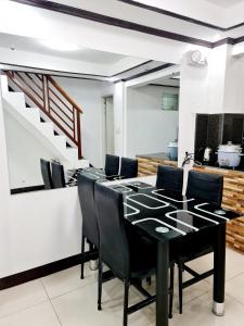 een eetkamer met een zwarte tafel en zwarte stoelen bij Calapan City Transient House Acacia L31 in Calapan