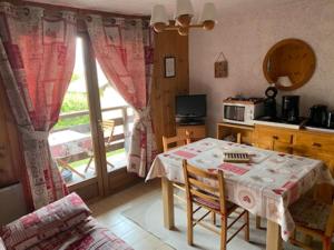 a kitchen with a table and a table and a window at La Coupe De Cristal in Saint-Gervais-les-Bains