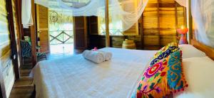 um quarto com 2 rolos de toalhas numa cama em Finca Flor de Maria em Santa Marta