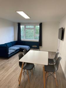 a living room with a table and chairs and a couch at Modern big 2 bedroom in Northolt with terrace parking in Northolt