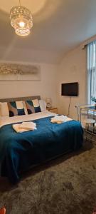 ein Schlafzimmer mit einem großen Bett mit einer blauen Decke in der Unterkunft Lawnswood Apartments in Blackpool