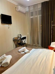 a hotel room with a bed with towels on it at Hotel Marioni in Tbilisi City