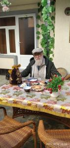 a man sitting at a table with a plate of food at Nur-Niso Guest House in Bukhara