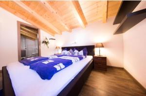 una camera da letto con un grande letto con lenzuola blu e bianche di Alpensweet by Northsouth Apartments a Sölden
