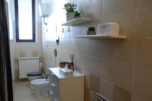 La salle de bains est pourvue de toilettes, d'un lavabo et d'étagères. dans l'établissement La finestra sul viale, à Pise