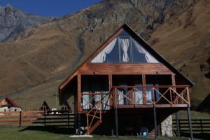 eine Scheune mit einem Berg im Hintergrund in der Unterkunft Cottage Mtachy in Kazbegi