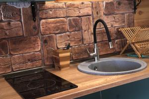 a kitchen counter with a sink and a stone wall at Cottage Mtachy in Stepantsminda