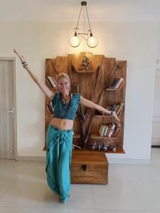 a woman is standing in front of a book shelf at Soul'Stay- A HomeStay & Retreat Center in Agra