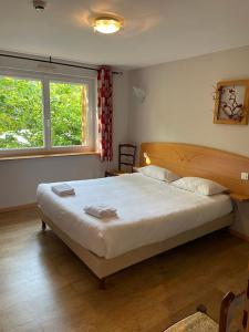 - une chambre avec un grand lit et une fenêtre dans l'établissement Notre Dame des Monts, à Ban-sur-Meurthe-Clefcy