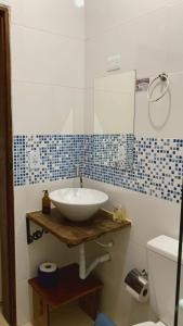 a bathroom with a sink and a toilet at Suites surf house itamambuca in Ubatuba