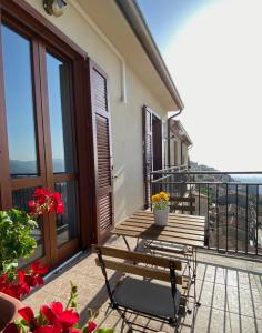 einen Balkon mit einem Tisch, Stühlen und Blumen in der Unterkunft Nonna Felicia B&B in Muro Lucano