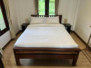 a large bed in a room with two windows at Good View House - Koh Yao Noi in Ko Yao Noi