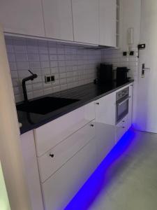 eine Küche mit weißen Schränken und einer schwarzen Arbeitsplatte in der Unterkunft Moderní industry studio in Prag