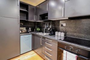 uma cozinha com electrodomésticos em aço inoxidável e pisos em madeira em Spacious 4-Bed in St.John's Wood em Londres