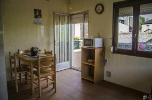 a small kitchen with a table and a microwave at Casa Rural El Cabo in Carucedo