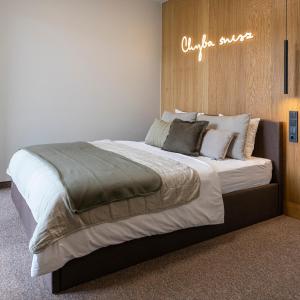 1 cama grande en un dormitorio con un cartel en la pared en Apartament Premium Laguna Beskidów, Jezioro Żywieckie en Bierna