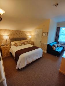a bedroom with a large bed and a blue couch at The Pack o' Cards in Combe Martin