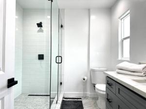 uma casa de banho branca com um chuveiro e um WC. em The Village House em Garnsey