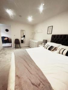 a white bedroom with a large bed and a desk at Exquisite Long-Term Living in Cardiff's Heart in Cardiff