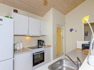 una cocina con armarios blancos y fregadero en 10 person holiday home in Brovst, en Brovst