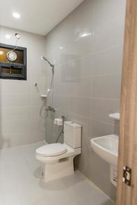 La salle de bains blanche est pourvue de toilettes et d'un lavabo. dans l'établissement DUQUM PLAZA HOTEL, à Duqm
