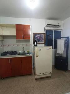 a kitchen with a white refrigerator and a sink at APARTAESTUDIO LA 27 in Barranquilla