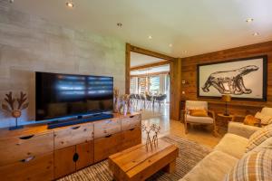 a living room with a large flat screen tv at Chalet le 4 - 13 personnes in Le Grand-Bornand