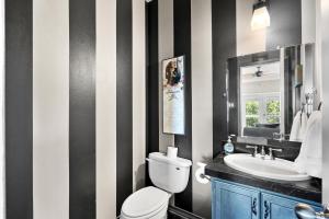 a bathroom with a black and white striped wall at Brand New Lake Travis Estate - Awesome Pool in Austin