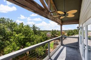 a view from the balcony of a house with a ceiling fan at Brand New Lake Travis Estate - Awesome Pool in Austin