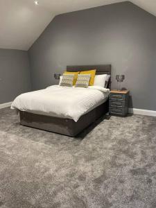 a bedroom with a large bed with yellow pillows at The Stone Barn in Magheralin