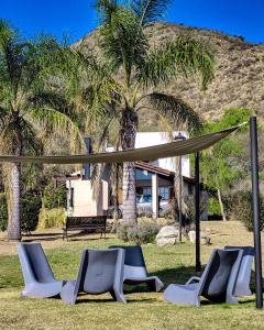 a group of chairs and a canopy in a park at Cabañas Loma Azul in Villa General Belgrano