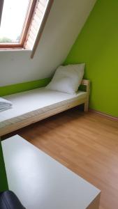 Bett in einem Zimmer mit grüner Wand in der Unterkunft Private Unterkunft, ruhige Lage in Nordhorn-Klausheide in Nordhorn