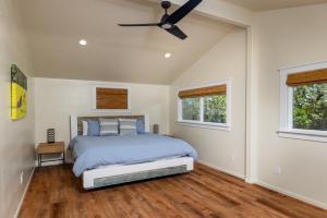a bedroom with a bed and a ceiling fan at A Cozy Cabin In The Country in Hawi